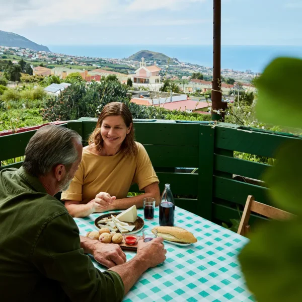 Pareja disfrutando de comida tradicional canaria en un guachinche en La Orotava