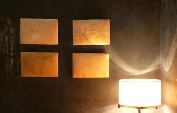 Detalle de iluminación y arte en pared con luz cálida en el Hotel San Roque