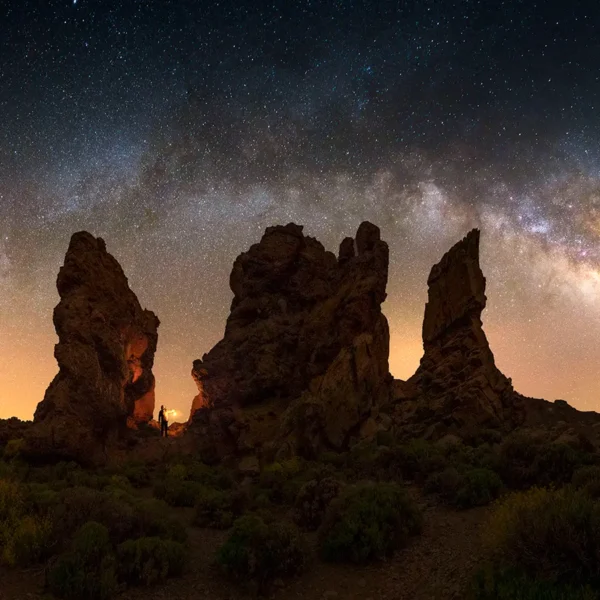 Observación de estrellas en el Parque Nacional del Teide con formaciones volcánicas iluminadas bajo el cielo nocturno