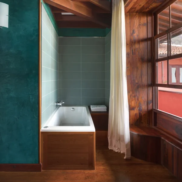 Habitación dúplex con bañera junto a la ventana y luz natural en el Hotel San Roque