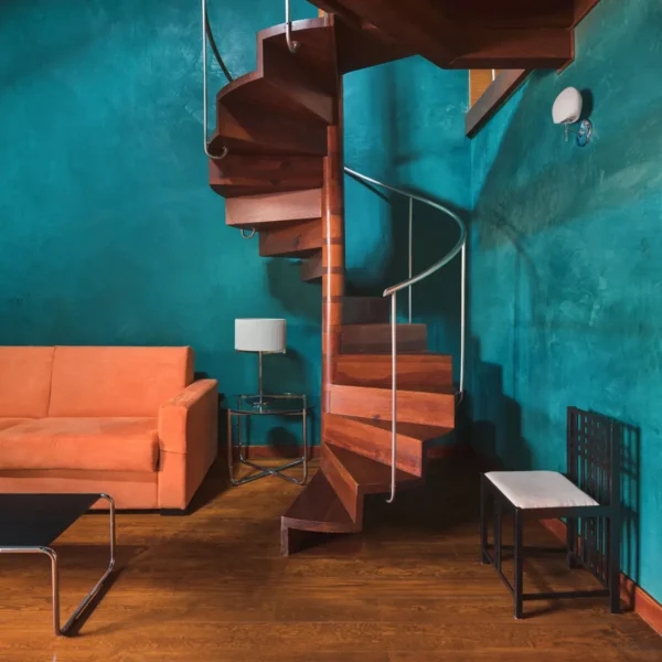 Habitación con escalera de caracol, sofá y paredes en tonos azules en el Hotel San Roque Garachico