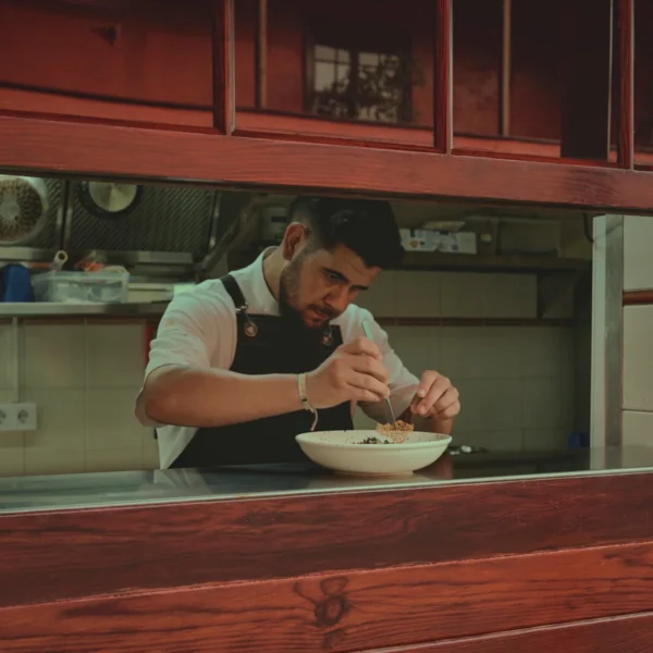 Cocinero emplatando en cocina abierta del restaurante Anturium en el Hotel San Roque